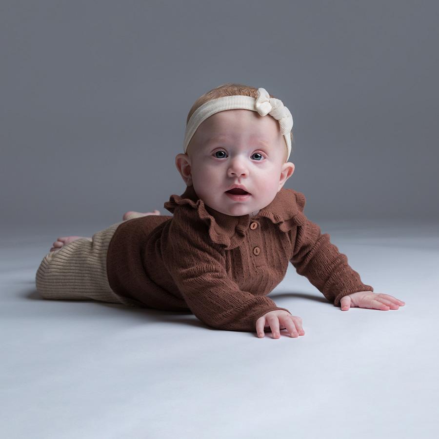 Photo studio d'un bébé qui rampe sur le sol